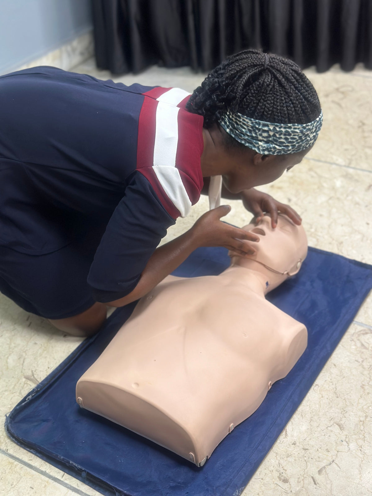 Nanny undergoing First Aid Training, practicing CPR 
